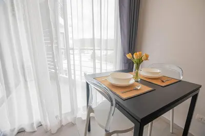 a black table with two chairs and a vase of flowers at 1BR Apartment near Villa Market - NV-423 in Phuket Town