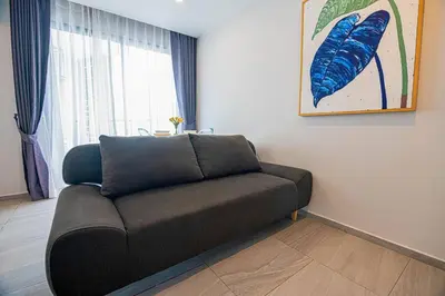 a couch sitting in a living room with a window at 1BR Apartment near Villa Market - NV-423 in Phuket Town