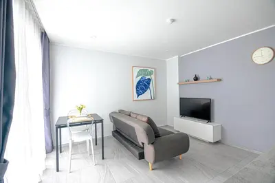 a living room with a couch and a tv and a table at 1BR Apartment near Villa Market - NV-423 in Phuket Town