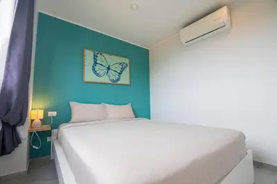 a bedroom with a white bed and a blue wall at Modern & Stylish Apartment-2BR - NV-518 in Phuket Town