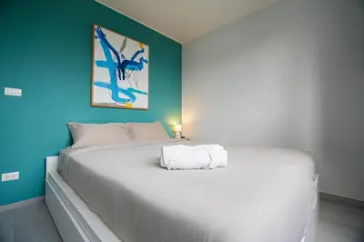 a large white bed in a room with a blue wall at Modern & Stylish Apartment-2BR - NV-518 in Phuket Town
