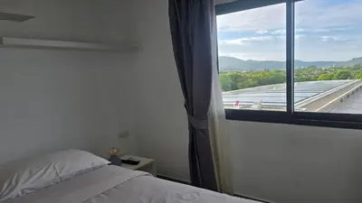 a bedroom with a bed and a large window at Tranquil Tide 1 BR T1-605 in Chalong