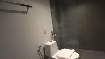 a bathroom with a toilet and a glass shower at Tranquil Tide 1 BR T1-605 in Chalong