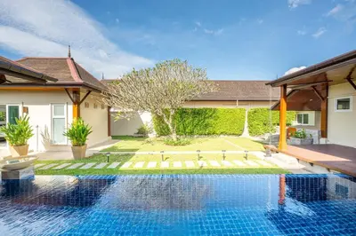 a swimming pool in the backyard of a house at Tranquil 3 Bedroom Garden Pool Villa in Laguna Phuket