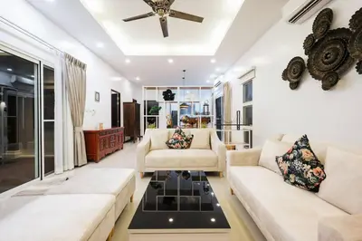 a living room with two couches and a ceiling fan at Tranquil 3 Bedroom Garden Pool Villa in Laguna Phuket