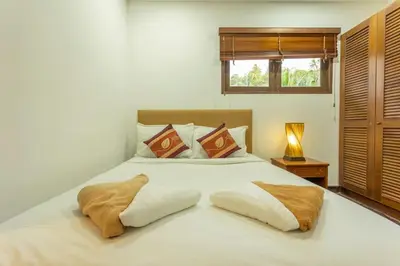 a bedroom with a large white bed with two pillows at Surin 4-Bed Luxury Retreat with Private Pool V131 in Thalang