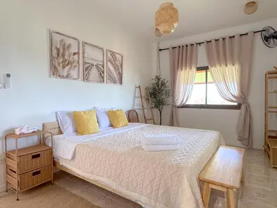 a bedroom with a large white bed with yellow pillows at Sea Dreamer Ao Yon Beach House in Ban Ao Makham