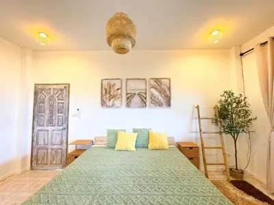a bedroom with a large green bed with yellow pillows at Sea Dreamer Ao Yon Beach House in Ban Ao Makham
