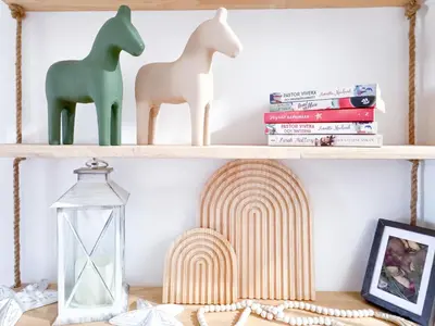 two wooden horses on a shelf with books at Sea Dreamer Ao Yon Beach House in Ban Ao Makham