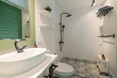 a white bathroom with a sink and a toilet at Stylish Penthouse at Bangtao Beach in Surin Beach