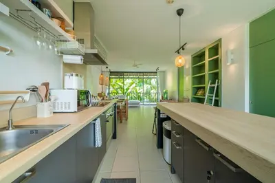 a large kitchen with a counter and a sink at Stylish Penthouse at Bangtao Beach in Surin Beach