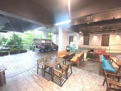 a room with wooden tables and chairs and a vehicle at Emerald Terrace Condo 9-1 Bed City & Mountain in Patong Beach