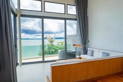 a living room with a large window overlooking the ocean at Eva8\u4e09\u5367\u6d77\u666f\u6cf3\u6c60\u522b\u5885\u4e34\u6d77\u522b\u5885 in Rawai Beach
