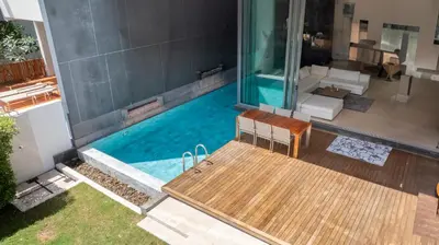 a swimming pool with a wooden table and a chair at Eva8\u4e09\u5367\u6d77\u666f\u6cf3\u6c60\u522b\u5885\u4e34\u6d77\u522b\u5885 in Rawai Beach