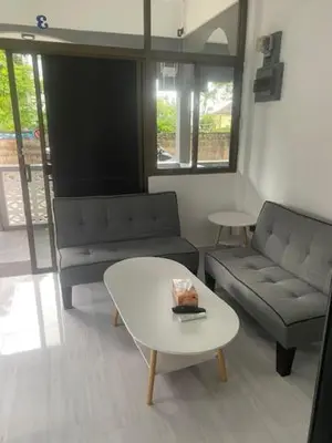 a living room with a couch and a table at Suthida Resort in Rawai Beach