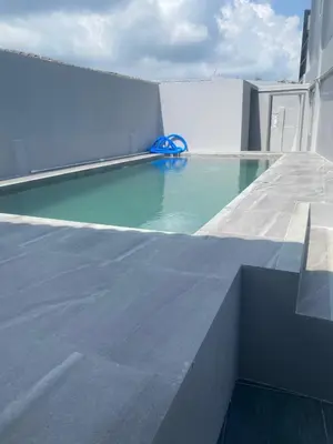 a swimming pool on the roof of a building at Suthida Resort in Rawai Beach