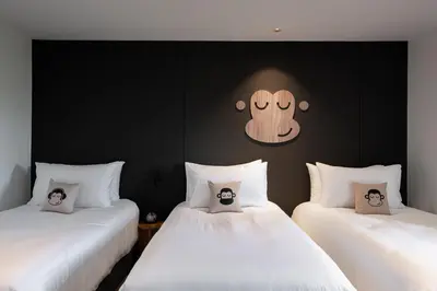 a room with two beds with a face on the wall at Blu Monkey Hub and Hotel Laguna, Bangtao Phuket in Bang Tao Beach