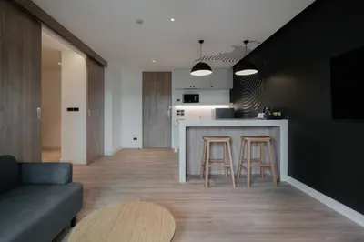 a kitchen and living room with a counter and stools at Blu Monkey Hub and Hotel Laguna, Bangtao Phuket in Bang Tao Beach