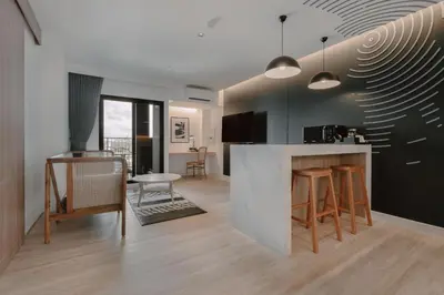a kitchen and living room with a counter and chairs at Blu Monkey Hub and Hotel Laguna, Bangtao Phuket in Bang Tao Beach