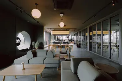a living room with couches and tables and a restaurant at Blu Monkey Hub and Hotel Laguna, Bangtao Phuket in Bang Tao Beach