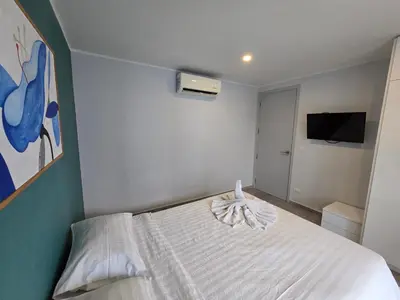 a white bed in a room with a tv at Well located Apt 1BR - T2-421 in Chalong