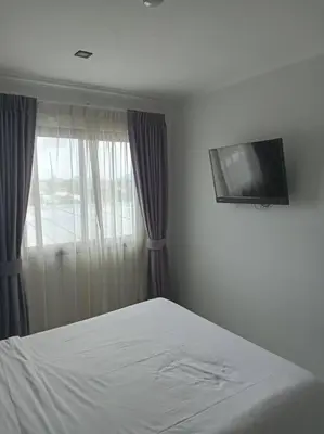 a bedroom with a bed and a tv on the wall at Fully Furnished Apartment - NV-622 in Chalong