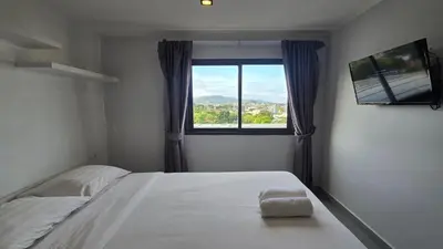 a bedroom with a bed and a window with a television at The Chalong Pearl 1BR T1-703 in Phuket Town
