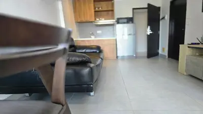 a living room with two leather couches and a kitchen at The Chalong Pearl 1BR T1-703 in Phuket Town