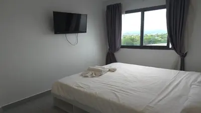 a bedroom with a bed and a flat screen tv at Urban loft 1BR T1-706 in Chalong