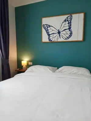 a bed with a butterfly picture on a blue wall at 2BR Aparment Near The Beach T2-717 in Phuket Town