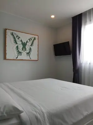 a bedroom with a bed with a butterfly picture on the wall at 2BR Aparment Near The Beach T2-717 in Phuket Town