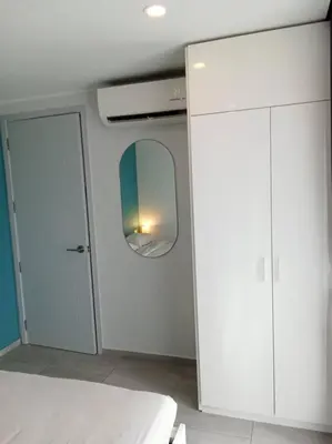 a white room with a mirror and a closet at Contemporary 1BR Condo - NV-724 in Phuket Town