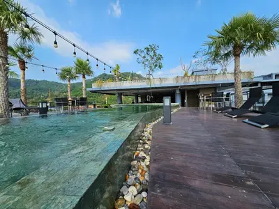 a swimming pool with a bridge and palm trees at 1BDR King size bed 3 Restaurants 500m to beach in Kamala Beach