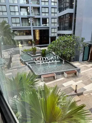 a building with a fountain in a courtyard with palm trees at 1BDR Roof pool 500m to beach Great gym Parking in Kamala Beach