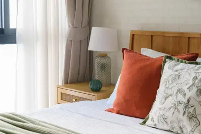 a bed with pillows and a lamp on a table at Title Halo Nature Touch 40m2 King Bed Naiyang in Nai Yang Beach