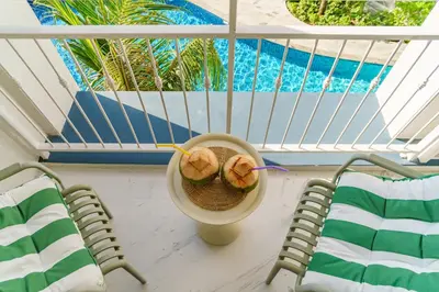 a bowl of fruit on a balcony with two chairs at Title Halo Nature Touch 40m2 King Bed Naiyang in Nai Yang Beach
