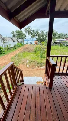 a wooden porch with a view of the ocean at Cheriya bungalow Kohyaonoi in Ban Laem Sai