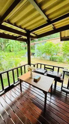 a wooden porch with a table and benches on a deck at Cheriya bungalow Kohyaonoi in Ban Laem Sai
