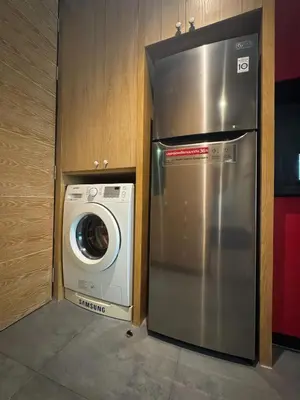 a stainless steel refrigerator next to a washing machine at ReLife NaiHarn Beach by Mill in Rawai Beach