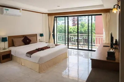 a bedroom with a large bed and a balcony at Global Hotel Beach View in Patong Beach