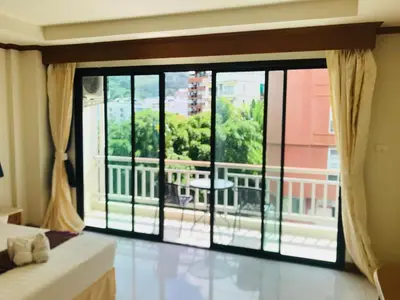a room with a large window with a view at Global Hotel Beach View in Patong Beach