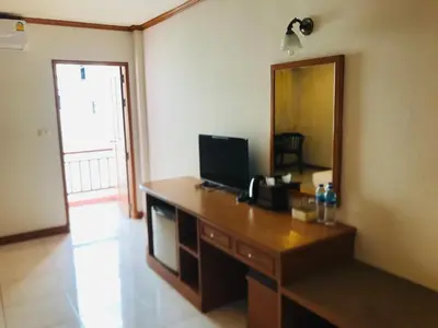 a room with a desk with a television and a mirror at Global Hotel Beach View in Patong Beach
