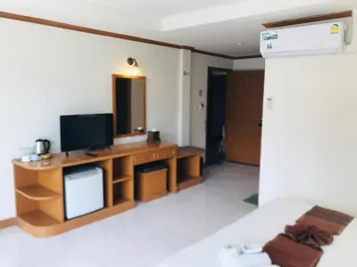 a living room with a television on a wooden desk at Global Hotel Beach View in Patong Beach