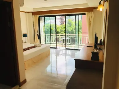 a living room with a large glass door with a balcony at Global Hotel Beach View in Patong Beach