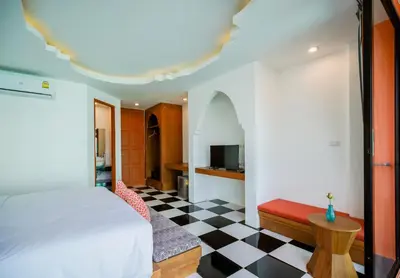 a bedroom with a bed and a checkered floor at Khaleej Mass Hotel Patong in Patong Beach