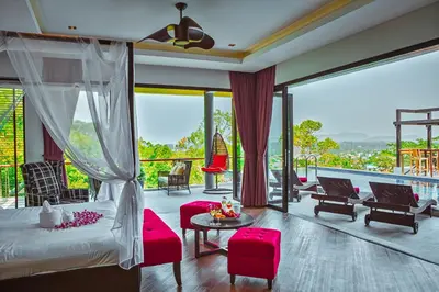 a bedroom with a bed and chairs and a balcony at Fully Serviced Grand Villa Luxury Time Phuket in Bang Tao Beach