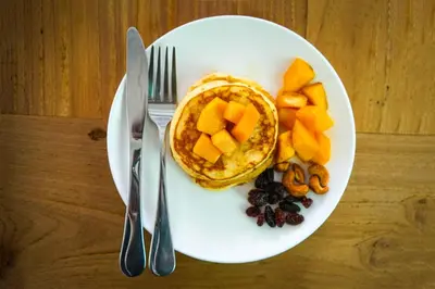 a plate with a waffle and fruit on a table at Fully Serviced Grand Villa Luxury Time Phuket in Bang Tao Beach