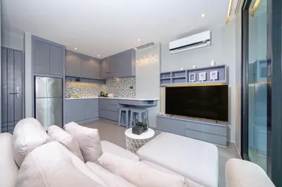 a living room with a white couch and a tv at Relax & Recharge in Modern Comfort at the Hill View Tropics Kamala Suite CTG L607 in Kamala Beach
