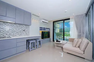 a living room with a couch and a tv in it at Relax & Recharge in Modern Comfort at the Hill View Tropics Kamala Suite CTG L607 in Kamala Beach