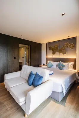 a bedroom with a large white bed and a couch at Studio Aurel 1BRTropical ViewsShuttle to NaiHarn in Rawai Beach